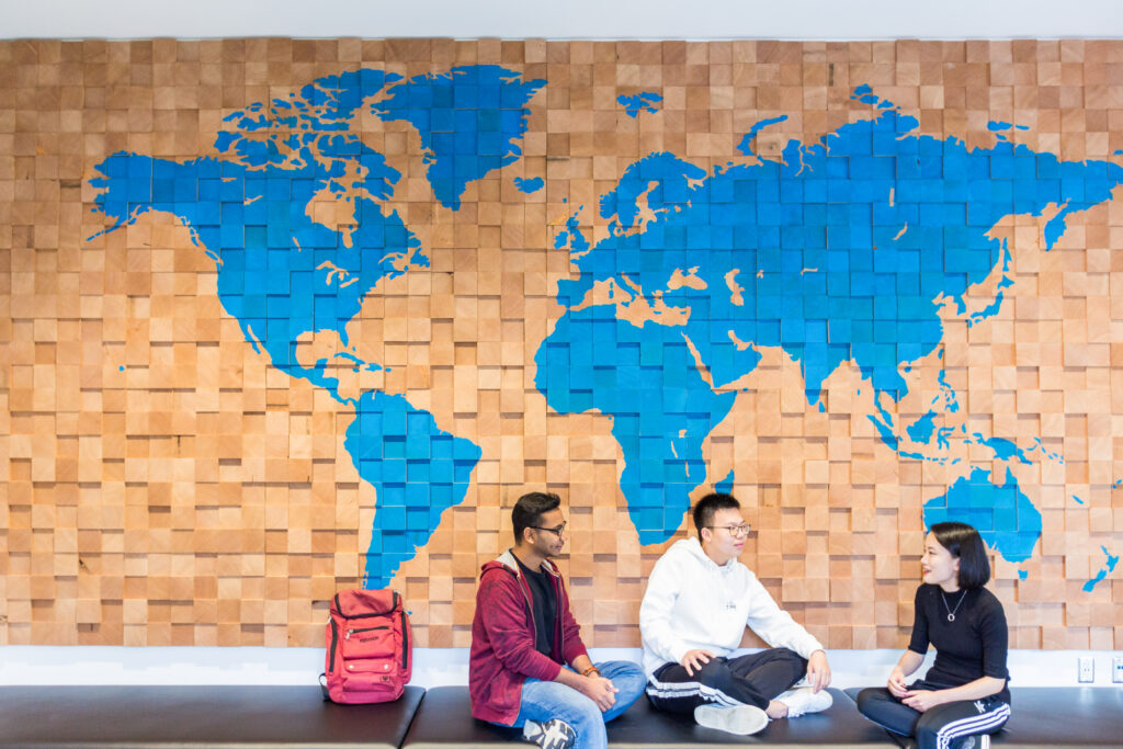 Students chatting by the map wall in Sherman Jen Building.